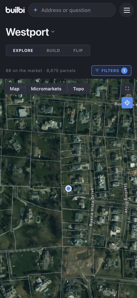 The map has flown to the phone's own position: a blue dot on the aerial with every parcel line around it.